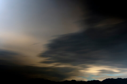 Clouds in a mood long exposure sky during twilight hours. A captivating long exposure image showcasing dark, swirling clouds against a subtle twilight backdrop, evoking a sense of mystery.