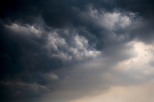 Dramatic dark clouds forming before a thunderstorm in the sky. A captivating view of ominous dark clouds gathering in the sky, creating a dramatic atmosphere that suggests an impending thunderstorm.