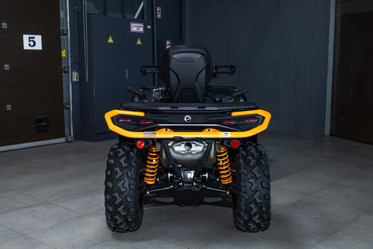 Aggressive black BRP Outlander ATV with striking orange accents. Powerful off-road beast on dark background, studio lighting, rugged design, extreme adventure vibe