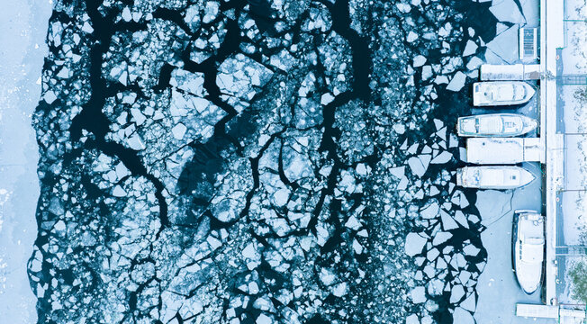 Aerial View of Frozen Boats Among Ice Floes on a Winter River