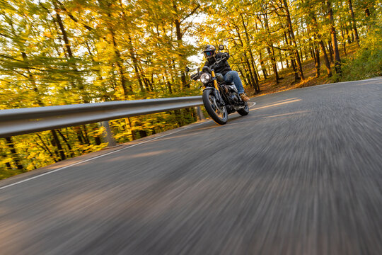 Motorcyclist Riding a Forest Road at Dusk