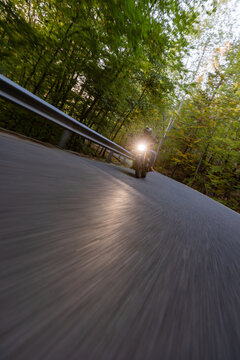 Motorcyclist Riding a Forest Road at Dusk