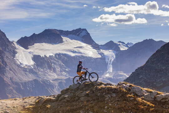 Mountain Biker Posing Below an Alpine Glacier