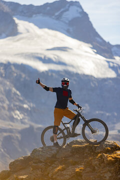 Mountain Biker Posing Below an Alpine Glacier