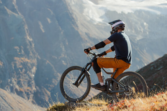 Mountain Biker Posing Below an Alpine Glacier