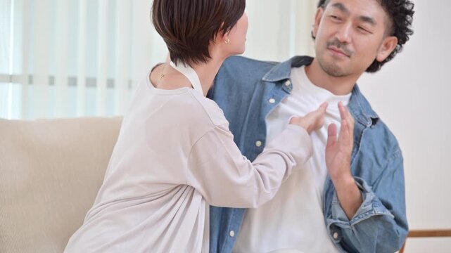 自宅のリビングで激しい取っ組み合いの夫婦喧嘩をする中年男女、家庭内トラブルや夫婦関係の悪化を表現したライフスタイルイメージの動画