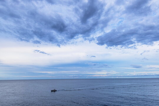 Barca a motore con mare calmo e cielo nuvoloso 
