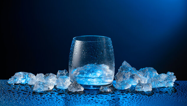 Vodka and crushed ice on a black table.