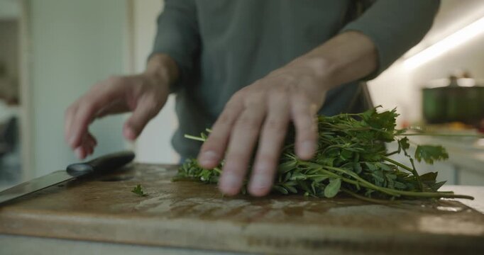 Close-up male hands chop cut green leaves herbs for salad. 4K 10-bit