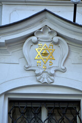 Gold star of david emblem on ornate pediment above window with iron grille for architectural detail and heritage building exterior © iri.madrid.art