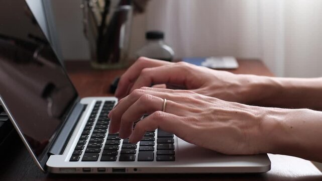 Close-up of Hands Typing on a Laptop at a Wooden Desk
木製デスクでノートパソコンをタイピングする手元のクローズアップ
