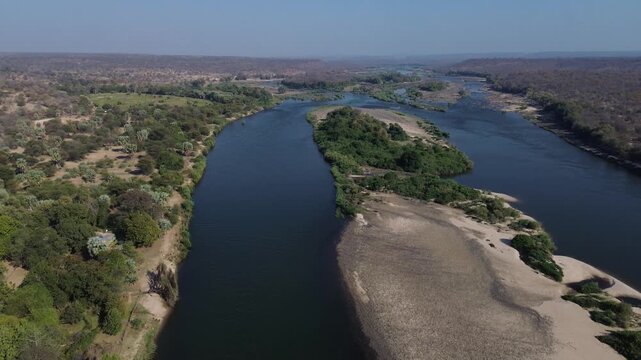 Camera panning up over a sandy island in the Zambezi River. 4K  Aerial Video.