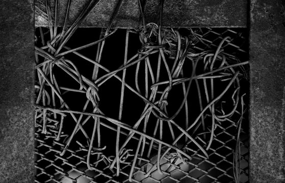 Broken jail fence. Escape. Defection. Night spotlight. Leave the jail Close Up view at the broken fence of prison. Escape. Barbed wires. Freedom gap in the chain-link fence repaired fixed with wire.
