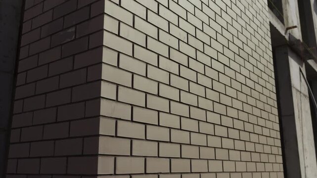 Close up of brick building facade corner with sunlight and shadow