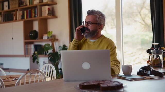 Man working from home office, drinking coffe and working on laptop.