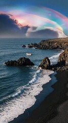 Naklejka premium Aerial view of black sand beach with ocean waves, rocky coast. Small boat floats on blue sea under colorful rainbow, dramatic sky. Peaceful coastal landscape in Portugal during sunset with beautiful