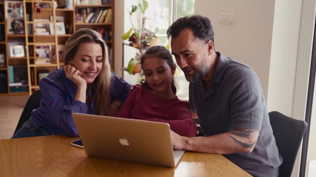 Parents and daughter booking holiday accommodation online.