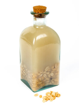 Rhum arrang&eacute; artisanal aux cacahu&egrave;tes dans une bouteille en verre avec bouchon en li&egrave;ge isol&eacute; sur fond blan