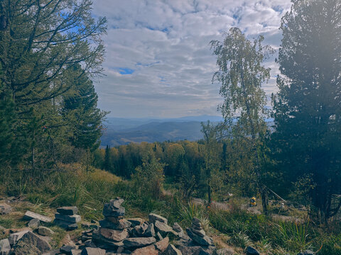 Stone cairns overlooking forest valley in mountains