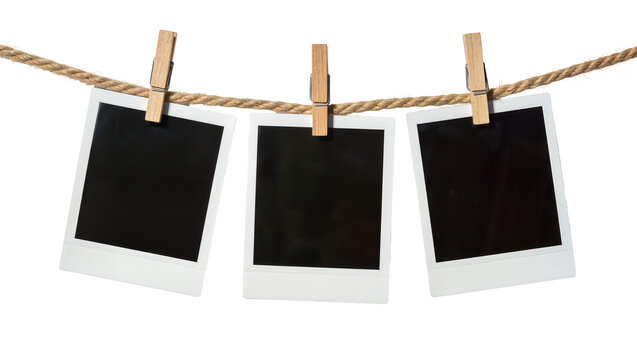 Three blank instant photo prints with wooden clothespins on a rope, isolated on transparent background