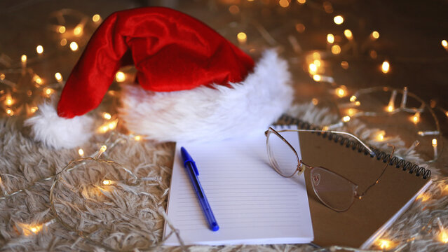 Santa hat and blank notebook, Christmas stationery and holiday gift planning with wish lists and seasonal organization.
