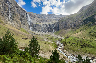 serene waterfall in mountainous landscape with rocky cliffs and green vegetation at high angle for nature photography and travel adventure themes with brown and blue tones and clean water. © Angelov