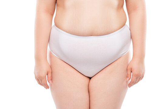 Concept of intimate woman's life. Cropped close up photo of chummy fatty woman's lower body, wearing big-sized panties, skin with stretch marks, sagged and dry, isolated on white background