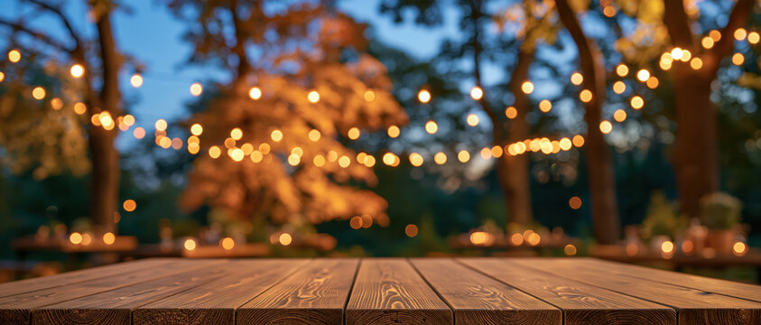 Rustic wooden table with blurred warm string light and autumn tree background
