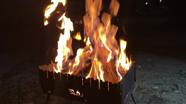 Flames rising from burning wood in brazier