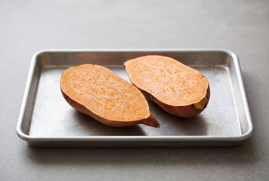 Sweet potato cut lengthwise on a baking tray