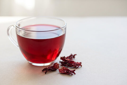 Hibiscus tea in a clear cup with dried petals