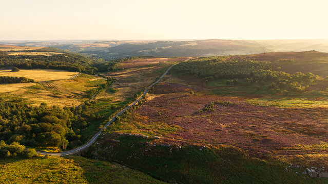 Beautiful drone landscape image view over Burbage South Edge in Peak District during Summer heather sunset