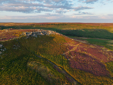 Beautiful drone landscape image view over Burbage South Edge in Peak District during Summer heather sunset