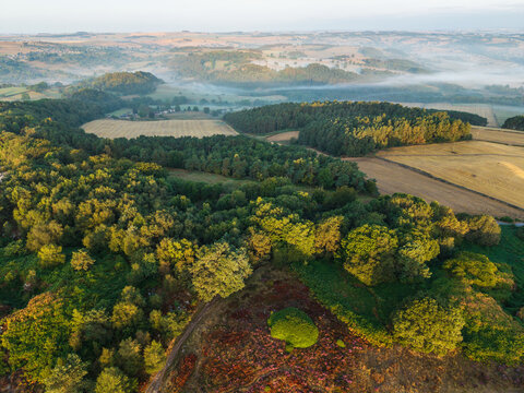 Beautiful drone landscape image over Stanton Moor in Summer Heather sunrise