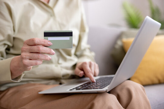 Woman shopping online with credit card on laptop
