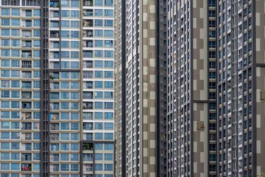 Full frame background view of dense windows and geometric wall patterns of high-rise apartment buildings.