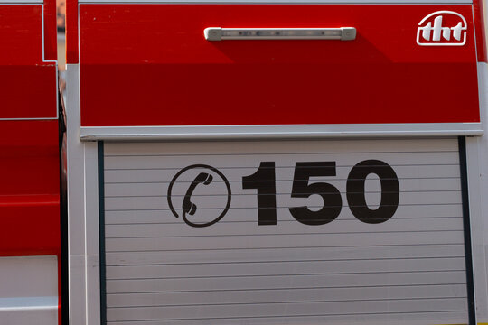 Pezinok, Slovakia, Europe - Sep 20, 2026: emergency phone number 150 and tht logo on red fire truck during wine festival emergency service event