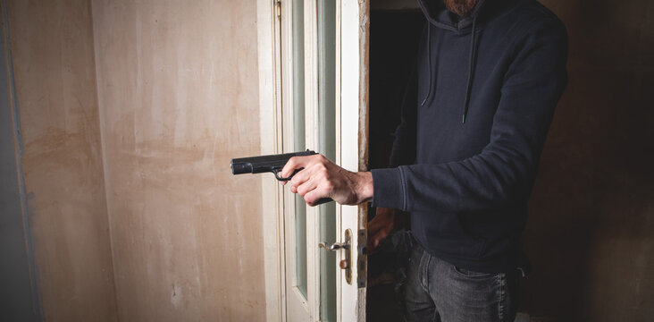 Man with a gun in the dark room.