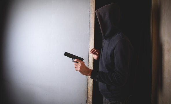 Man with a gun in the dark room.