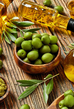 Fresh green olives, olive oil and rustic Mediterranean food arrangement