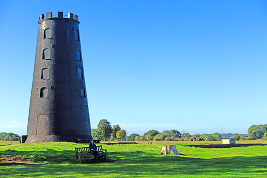Lady sat beneath the Black Mill, in Beverely, East Riding of Yorkshire, England.
