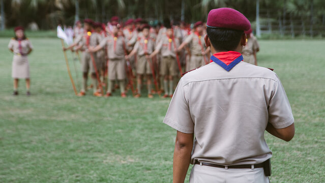 Rear View of Scoutmaster Training Boy Scouts Formation on School Field