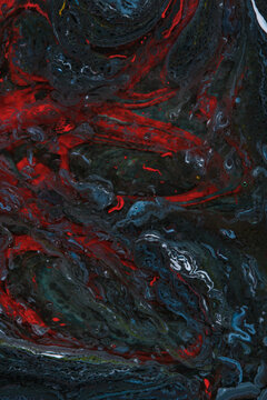 Dark moody fluid paint texture with intense red and dark blue swirls creating dramatic abstract art.