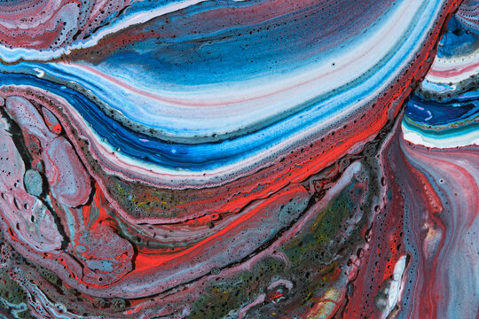 Smooth liquid acrylic marble pattern with bright blue, white, red, and dark swirling color lines.