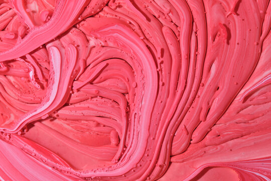 Thick textured pink and red liquid paint swirls forming rich dynamic waves and sculpted drops.