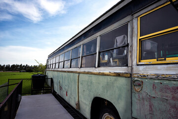 Vintage Abandoned Bus Beside Rice Fields in Sekinchan, Selangor, Malaysia - A weathered vintage bus with faded green paint and aged windows standing beside lush agricultural fields in Sekinchan. © lcchew