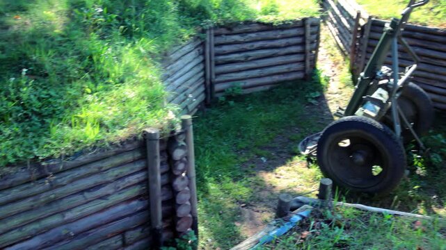 Military trench wooden log walls. Artillery cannon defensive position outdoors.