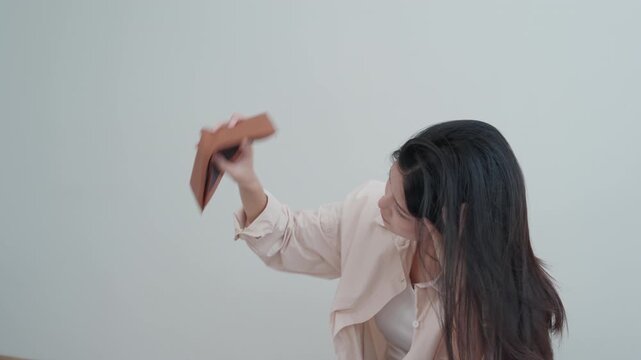 Stressed and headache asian woman with large bills or invoices no money to pay to expenses and credit card debt. shortage, Financial problems, mortgage, loan, bankruptcy, bankrupt, poor, empty wallet