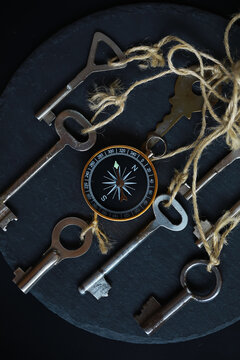 Vintage Keys and Compass on Dark Stone Surface for Navigation and Adventure Concepts