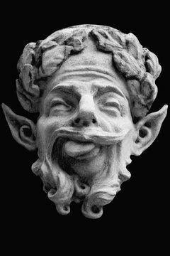 Ancient satyr face from Greek mythology with pointed ears and a mischievous expression, symbolizing wild nature, pleasure, instinct and unrestrained human desires.